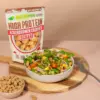 Hier ein Foto der Verpackung für die würzigen, proteinreichen Ackerbohnen-Crispies von NutriPur und eine Schüssel mit Salat und den Crispies als Topping
