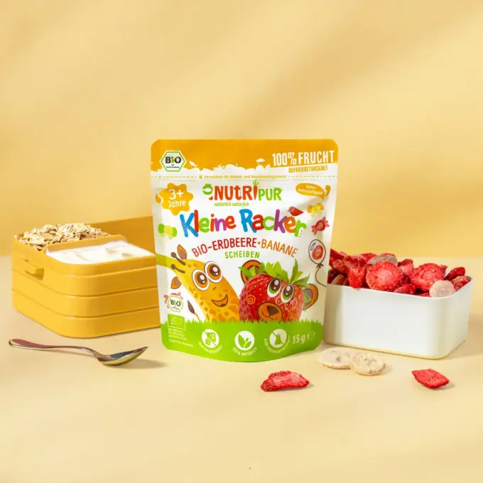 Bild zeigt die kleinen Racker der Sorte Bio-Erdbeere und Banane von NutriPur mit Joghurt und Flakes als Schulsnack in einer Brotdose