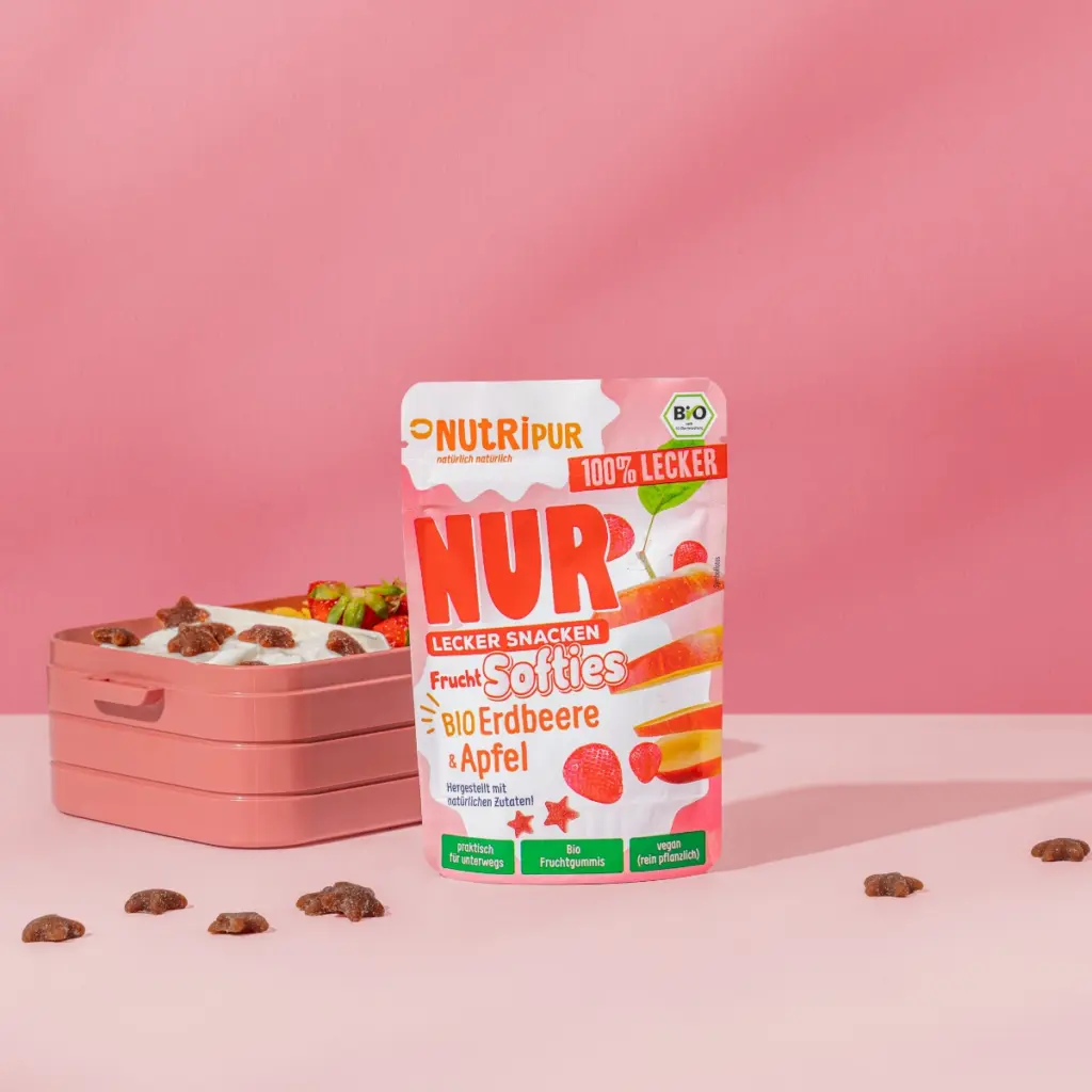 Bild zeigt die NUR Frucht Softies BIO Erdbeere & Apfel von Nutripur mit Verpackung und Brotdose