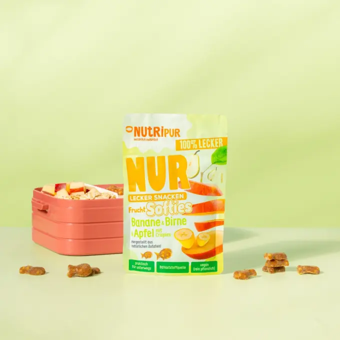 Bild zeigt die NUR Frucht Softies Banane, Birne & Apfel mit Crispies von Nutripur mit Verpackung und Brotdose