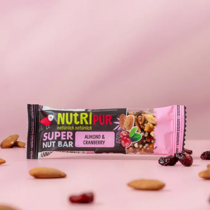 Detailbild des Nussriegels mit Mandeln und Cranberries im Vordergrund