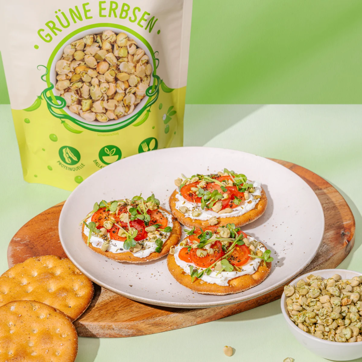 Bild zeigt grüne Erbsen-Knusperflakes als Topping auf Cracker mit Salatbett